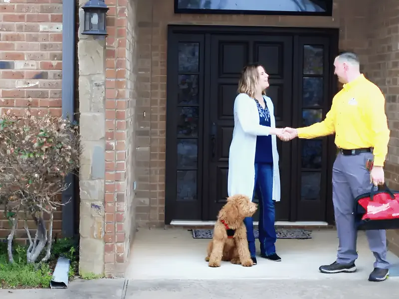 Uniformed technician greeting homeowner at the door, from Rub-A-Dub Plumbing’s own photographs.