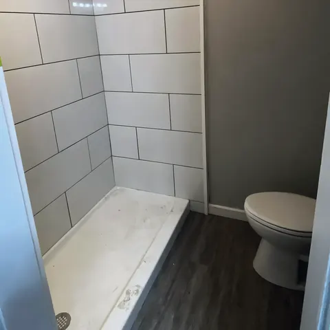 Walk-in shower and toilet, from Jennings Plumbing’s own photographs.