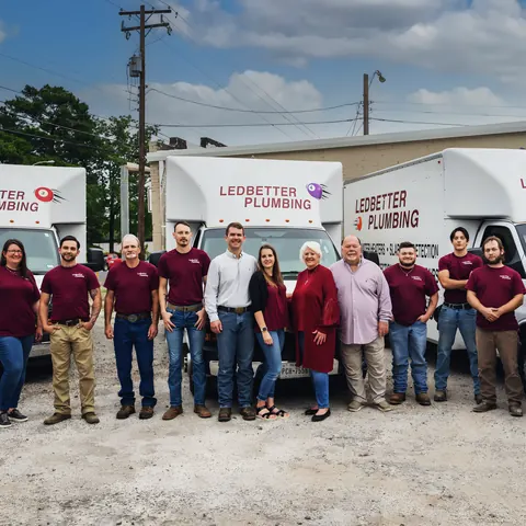 Full crew in front of branded box trucks, from Ledbetter Plumbing’s own photographs.